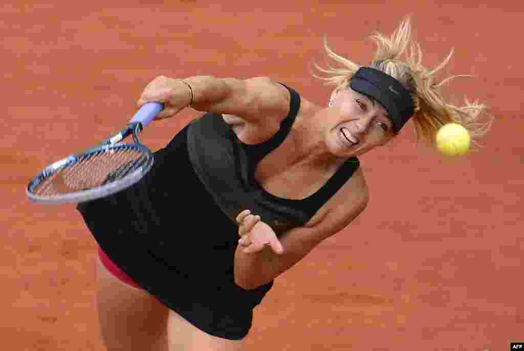 Russia&#39;s Maria Sharapova serves to Italy&#39;s Sara Errani on her way to winning the French Open women&#39;s singles final in Paris on June 9. (AFP/ Pascal/Guyot) 