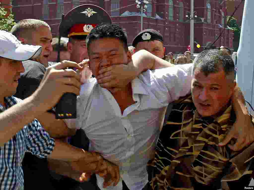 Plain-clothes police officers detain gay-rights activist Daniel Choi (center) near the Kremlin during an unsanctioned gay-pride parade in central Moscow on May 28, 2011.