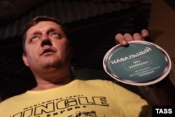 Oleg Pakholkov poses with part of what he alleges are illegal Navalny campaign materials.