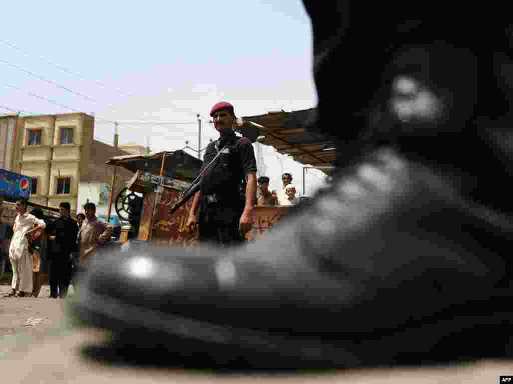 Pakistani police commandos stand alert in a restive Karachi neighborhood on June 16.Photo by Asif Hassan for AFP