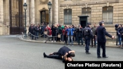 Охоронець затримує одну з активісток руху «Фемен» перед Єлисейським палацом, Париж, 9 грудня 2019 року