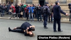 A man detains a Femen activist as she demonstrates in front of the Elysee Palace.