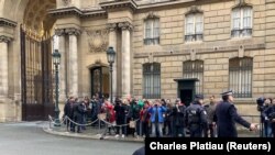 Охранник задерживает одну из активисток движения «Фемен» перед Елисейским дворцом, Париж, 9 декабря 2019 года