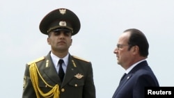 Armenia -- French President Francois Hollande walks past an honor guard as he attends a commemoration ceremony marking the centenary of the mass killing of Armenians by Ottoman Turks in Yerevan, April 24, 2015