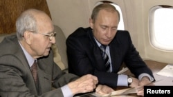 Ветеран Иван Мартынушкин (слева) и президент России Владимир Путин на борту президентского лайнера летят в Польшу на мероприятия, посвященные освобождению Освенцима. Январь 2005 года.