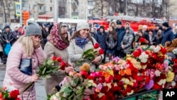 Люди несуть квіти до імпровізованого меморіалу жертв пожежі в торговельному центрі у Кемерові, Росія, 26 березня 2018 року