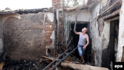 Сотрудник министерства по чрезвычайным ситуациям Кыргызстана осматривает дом, разрушенный в ходе спецоперации по ликвидации террористической группировки. Бишкек, 17 июля 2015 года.