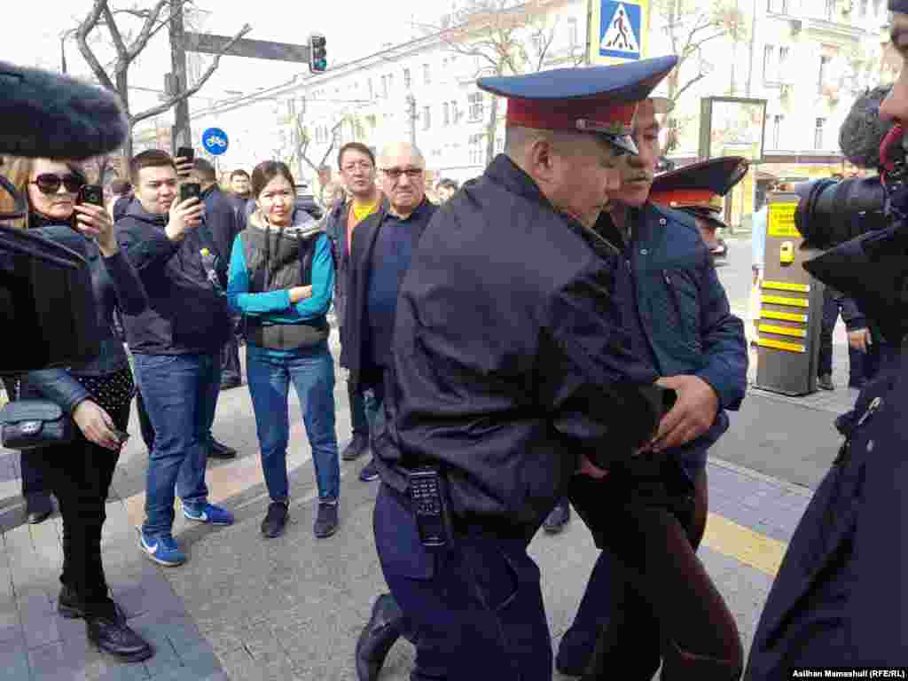 Полицейские забирают человека, заявлявшего, что он &quot;пришел на празднование Наурыза&quot;. Алматы, 22 марта 2019 года.&nbsp; &nbsp;
