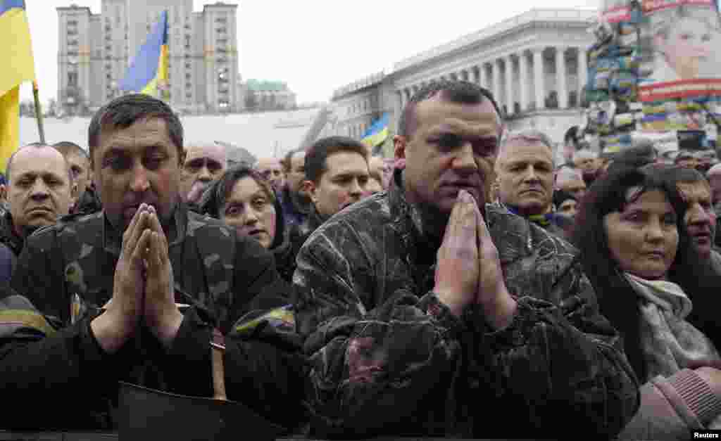 People pray during a funeral service for antigovernment protesters.