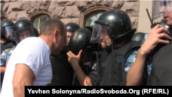 An opposition protester talks to riot policemen guarding the Kyiv city administration compound on July 11.