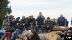 Kosovo Serbs sit on a barricade at the entrance to the village of Zupce, in northern Kosovo, on October 21.