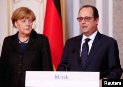 German Chancellor Angela Merkel (left) and French President Francois Hollande address the media after taking part in peace talks on resolving the Ukrainian crisis in Minsk on February 12, 2015.