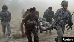 U.S. and Afghan troops carry a wounded U.S. soldier through a dust cloud to a helicopter after he was injured by a roadside bomb in Kandahar Province on October 13.