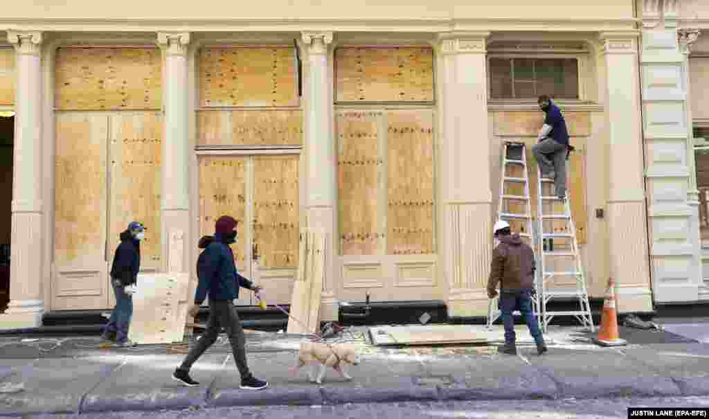 Робітники закривають фанерою вікна крамниць у районі Сохо в Нью-Йорку. 2 листопада 2020 року
