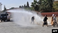 Turkish police fire water cannon to disperse Syrian nationals who crossed the border after Syrian aircraft bombed a strategic border town on November 12.