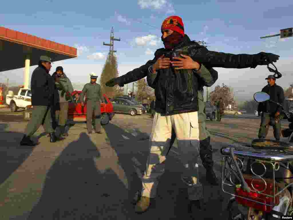 An Afghan policeman searches a man at a checkpoint on the first day of the Loya Jirga, or grand assembly, in Kabul on November 16. (REUTERS/Omar Sobhani)