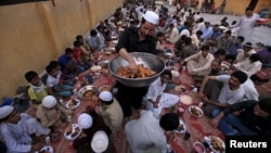 A man distributes samosas, a traditional delicacy to men before breaking their fast in Rawalpindi, Pakistan on June 19.
