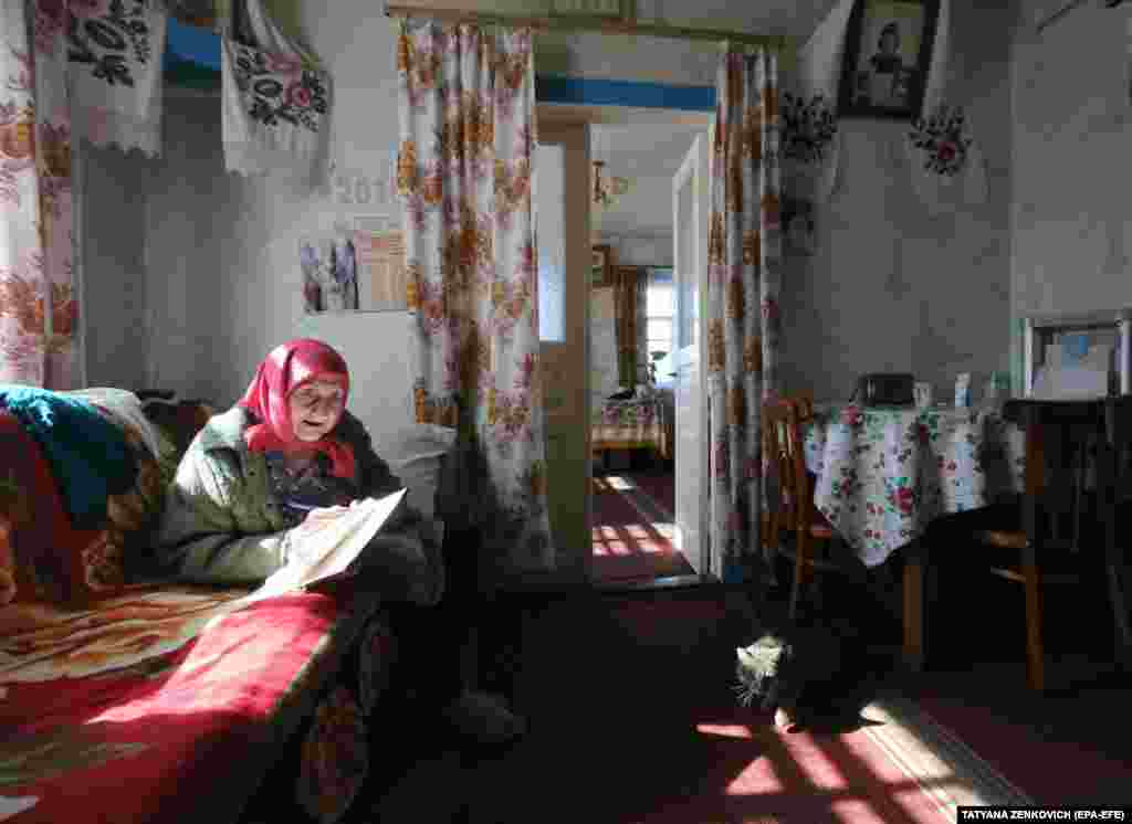 Kataryna Bidnosheya studies her ballot papers in the village of Velyki Dmytrovychi, central Ukraine. (EPA-EFE / Tatyana Zenkovich)