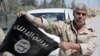 A Syrian government soldier displays an Islamic State (IS) group flag after Syrian troops regained control the previous day of Al-Qaryatain, a town in the province of Homs, earlier this month.