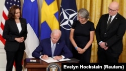 Президент США Джо Байден вместе с вице-президентом Камалой Гаррис (слева), послом Швеции в США Карин Олофсдоттер и послом Финляндии в США Микко Гауталом подписывают документы, подтверждающие вступление Финляндии и Швеции в НАТО. Вашингтон, 9 августа 2022 года