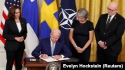 U.S. President Joe Biden -- alongside Vice President Kamala Harris (left), Swedish Ambassador to the United States Karin Olofsdotter (second from right), and Finnish Ambassador to Washington Mikko Hautala -- signs ratification documents for the Nordic countries to join NATO in Washington on August 9. 