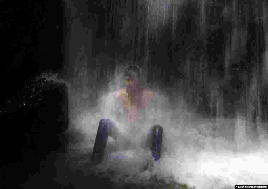 A boy cools off under a waterfall on the outskirts of Kathmandu in Nepal. (Reuters/Jose Luiz Gonzalez)