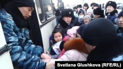Тұрғын үй проблемасына байланысты наразылық танытқан адамдарды балаларымен бірге полиция көлігіне тиеп жатыр. Астана, 6 наурыз 2014 жыл.