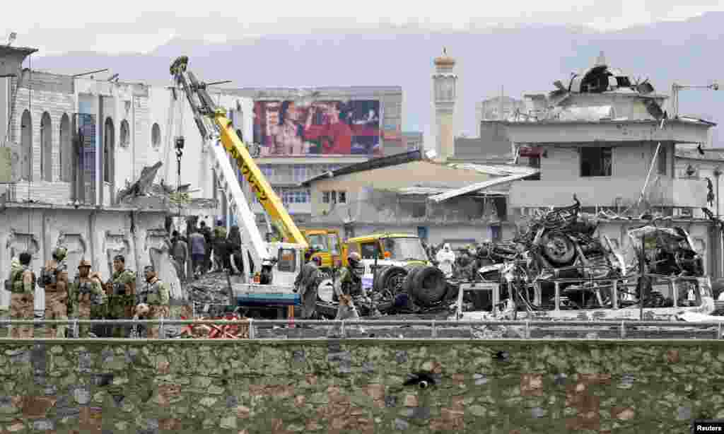 Afghan security forces inspect the site of the suicide car-bomb attack.