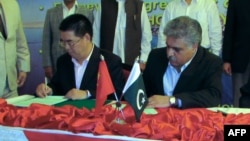 Chairman of Pakistan's Gwadar Port Authority Dostain Khan Jamaldini (R) and chairman of China Overseas Port Holding Company (COPHC), Zhan Baozhang (L) sign a document during a ceremony in the Gwadar in November.