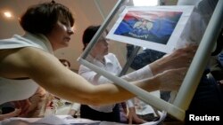 Members of a local separatist election commission empty a ballot box as they start counting votes of the referendum on the status of Donetsk region in Donetsk on May 11.