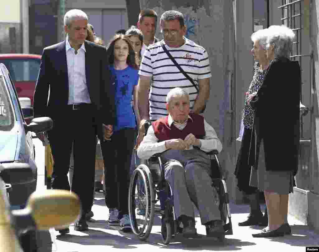 Tadic (left) was accompanied to a downtown-Belgrade polling station on May 20 by daughter Vanja and father Ljuba Tadic (in wheelchair). (REUTERS/Ivan Milutinovic)