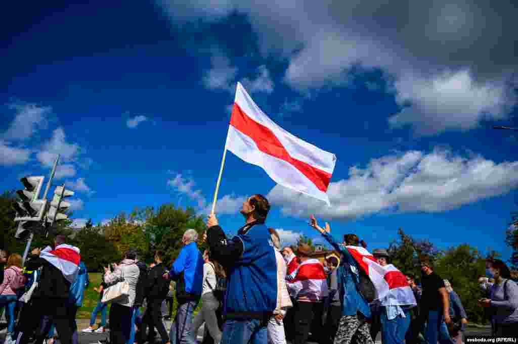 A man carrying an old Belarusian national flag takes part in an anti-government rally in Hrodna on September 13. (RFE/RL)