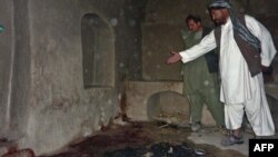 A villager points to a spot where a family was allegedly shot in their residence by a rogue U.S. soldier in the village of Alekozai in Kandahar Province.