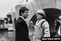 Fotografie din 18 septembrie 1985. Ministrul francez al Culturii Jack Lang (stânga), discută cu artistul bulgaro-american Christo în timpul ce acesta împacheta Pont Neuf.