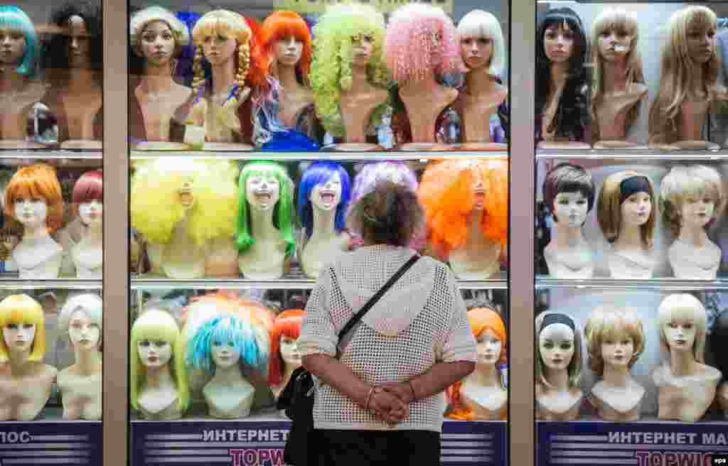 An elderly woman looks into a shop selling wigs in a shopping mall in downtown Kyiv. (epa/Roman Pilipey)