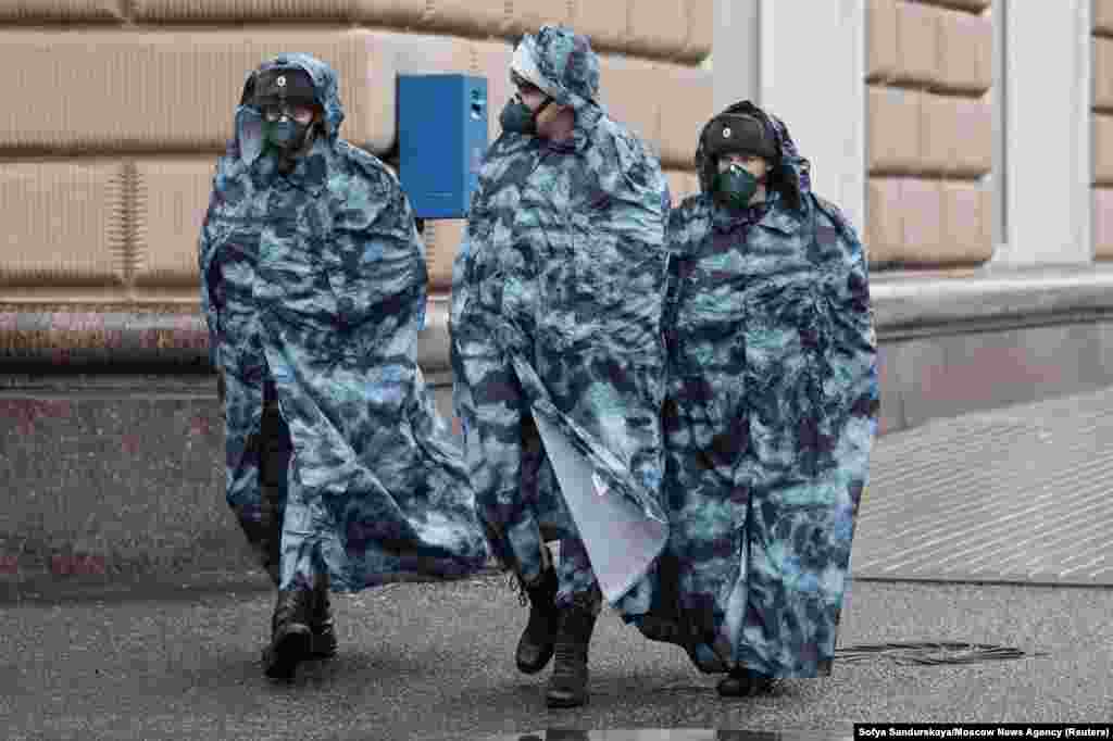 Расейскія праваахоўнікі ў плашчах і ахоўных масках патрулююць вуліцы ў Маскве падчас пандэміі.&nbsp;