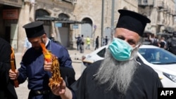 Священник Греческой православной церкви с благодатным огнем, Иерусалим, 18 апреля 2020 года
