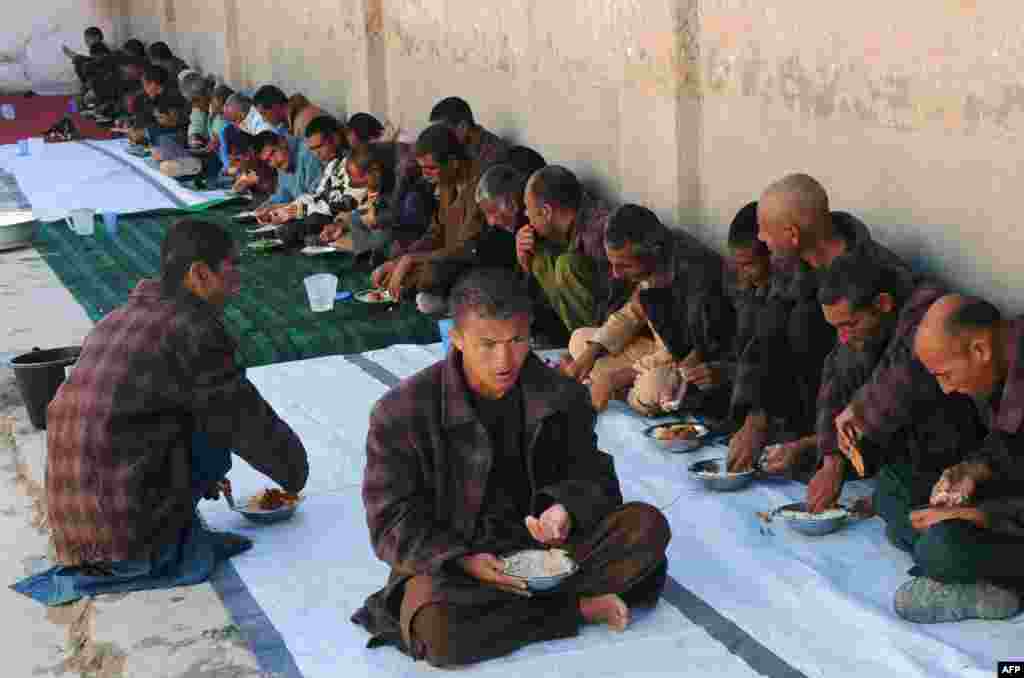 Afghan patients eat inside a Red Cross mental health shelter on the outskirts of Herat. The shelter is run by the Red Crescent and currently treats more than 150 men and 20 women, providing food, sleeping facilities, and other health-care needs. (AFP/Aref Karimi)