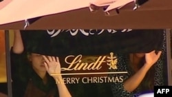 Кадр австралийского телеканала Channel Seven, на котором видны предполагаемые заложники и флаг с арабской надписью. Сидней, 15 декабря 2014 года.
