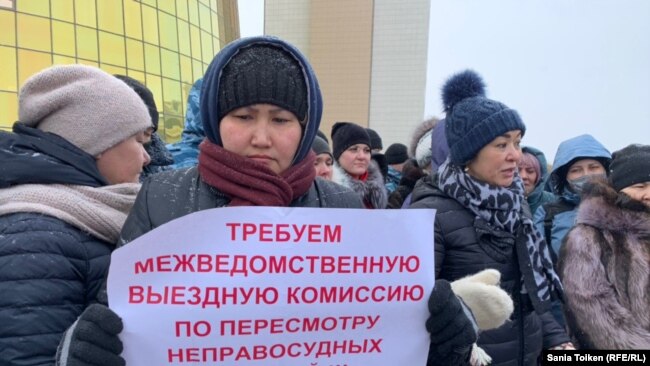 Мадина Кукетаева на протестной акции у башен Дома министерств с плакатом с надписью с призывом «пересмотреть неправосудные судебные акты». Нур-Султан, 17 февраля 2020 года.