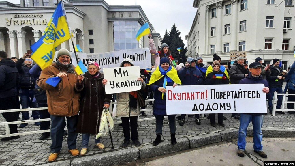 Люди стоять перед військовими Росії під час мітингу проти російської окупації. Херсон, 13 березня 2022 року