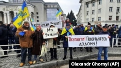 Люди стоят перед военными России во время митинга против российской оккупации. Херсон, 13 марта 2022 года