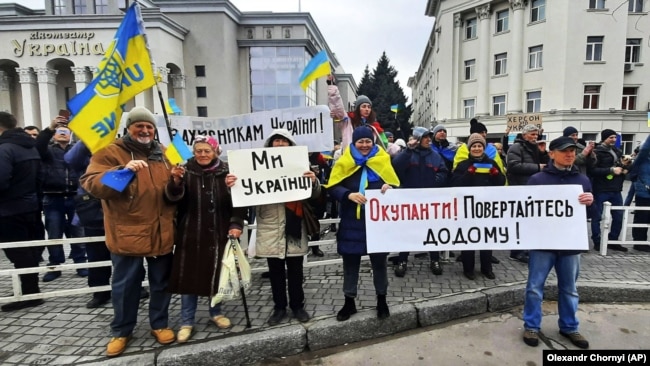Люди стоять перед військовими Росії під час мітингу проти російської окупації. Херсон, 13 березня 2022 року
