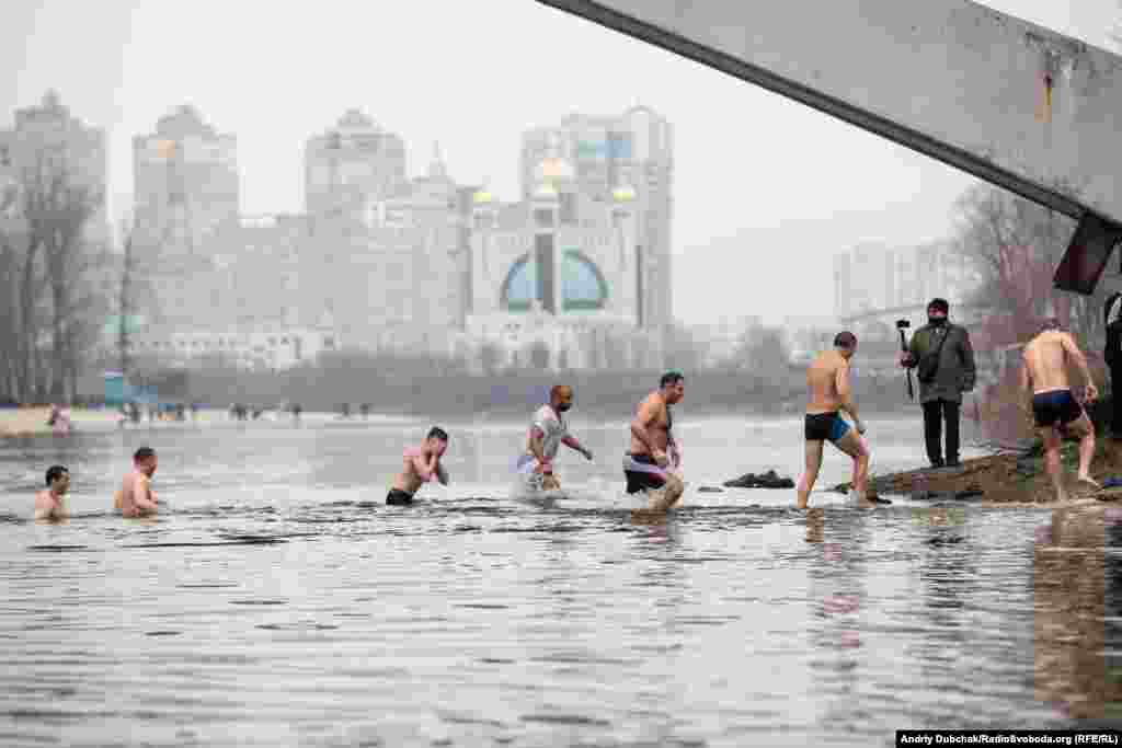 Participants walk back onto the shores of the Dnieper River. Temperatures in the Ukrainian capital this January 19 were around minus 2 degrees Celsius.