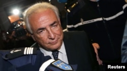 Former IMF head Dominique Strauss-Kahn is escorted by gendarmes while leaving the Paris courts after a hearing in February.