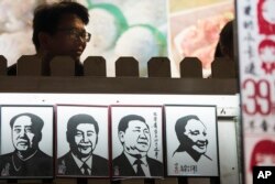 Портреты китайских коммунистических вождей в туристическом районе Шанхая. Си Цзиньпин (два центральных портрета) изображен в компании Мао Цзэдуна (слева) и Дэн Сяопина (справа)