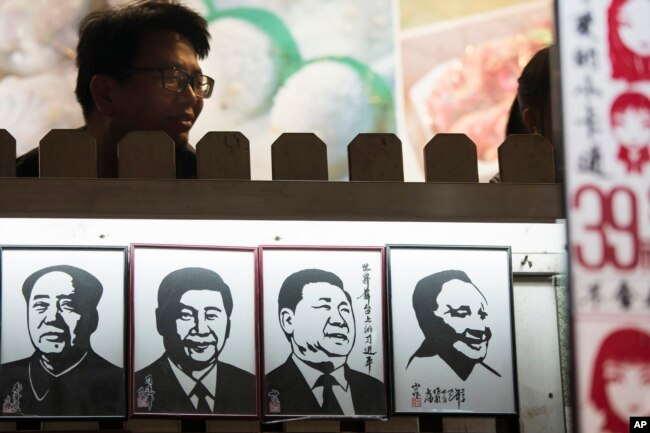 Портреты китайских коммунистических вождей в туристическом районе Шанхая. Си Цзиньпин (два центральных портрета) изображен в компании Мао Цзэдуна (слева) и Дэн Сяопина (справа)