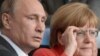 Brazil -- Russian President Vladimir Putin (L) and German Chancellor Angela Merkel watch the FIFA World Cup 2014 final between Germany and Argentina at the Estadio do Maracana in Rio de Janeiro, July 13, 2014