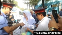 Милиция отбирает бутылку с бензином у матери Хусейна Абдусамадова