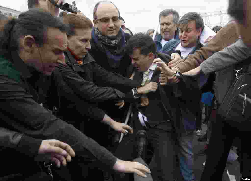 A gay-rights activist (center) scuffles with Orthodox Christian activists.